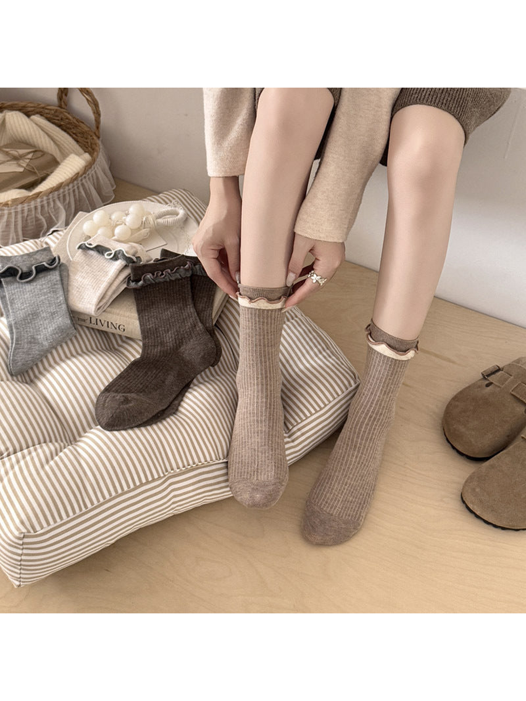 Light Coffee ribbed socks worn while seated, with hands adjusting a contrasting ruffled cuff.