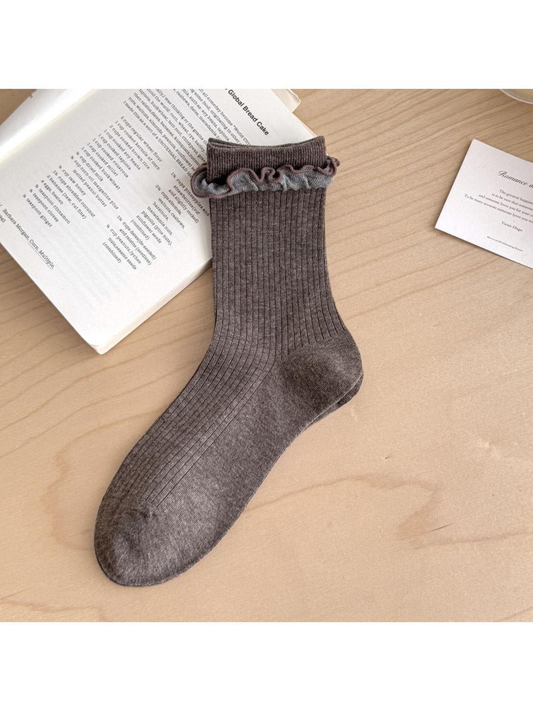 Coffee ribbed sock with contrasting gray ruffled trim below the cuff.