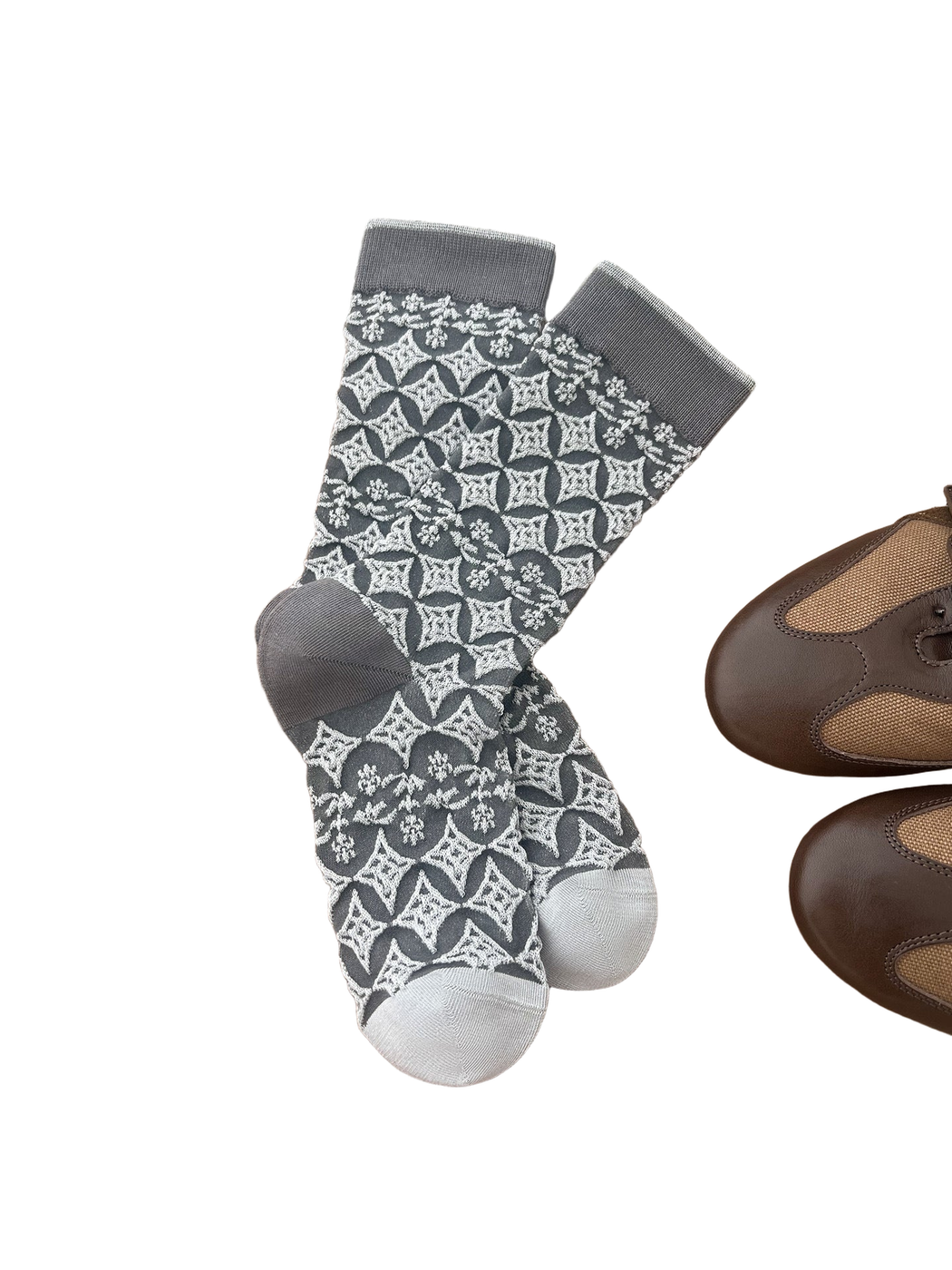 Gray socks with light diamond and floral patterns arranged on a wooden surface.
