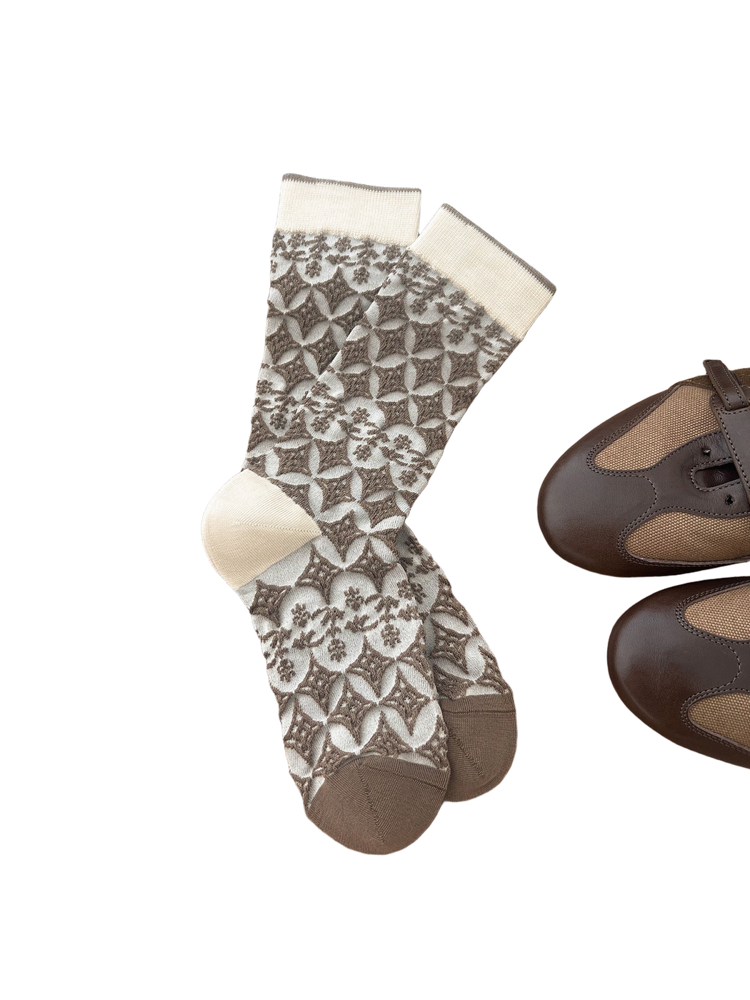 Brown and cream socks with diamond and floral patterns arranged on a wooden surface.