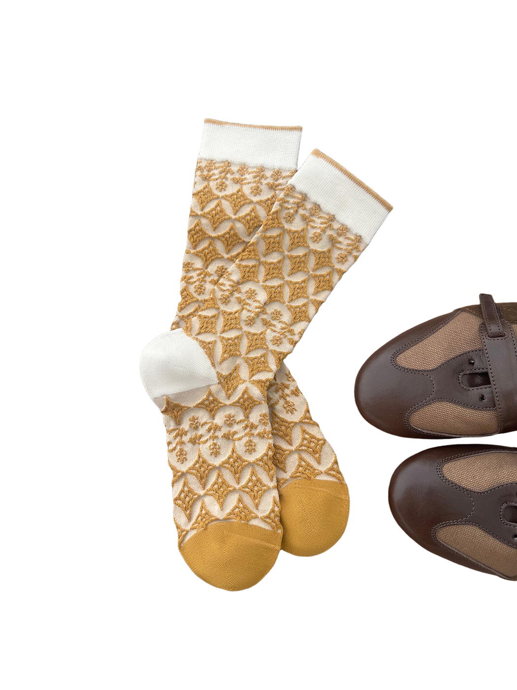 Mustard and cream socks with diamond and floral patterns arranged on a wooden surface.