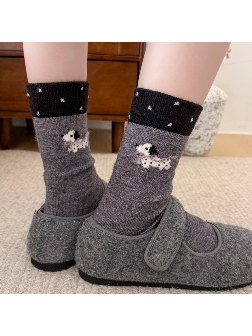 Dark gray socks with dotted black cuffs and dogs with purple scarves, worn with gray slippers.
