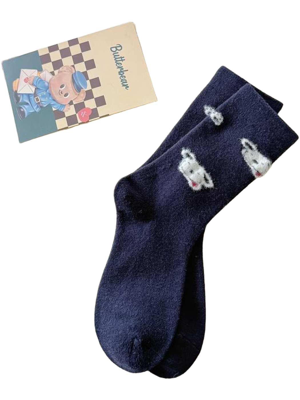 Navy Puppies socks with puppy motifs displayed on a cream throw.