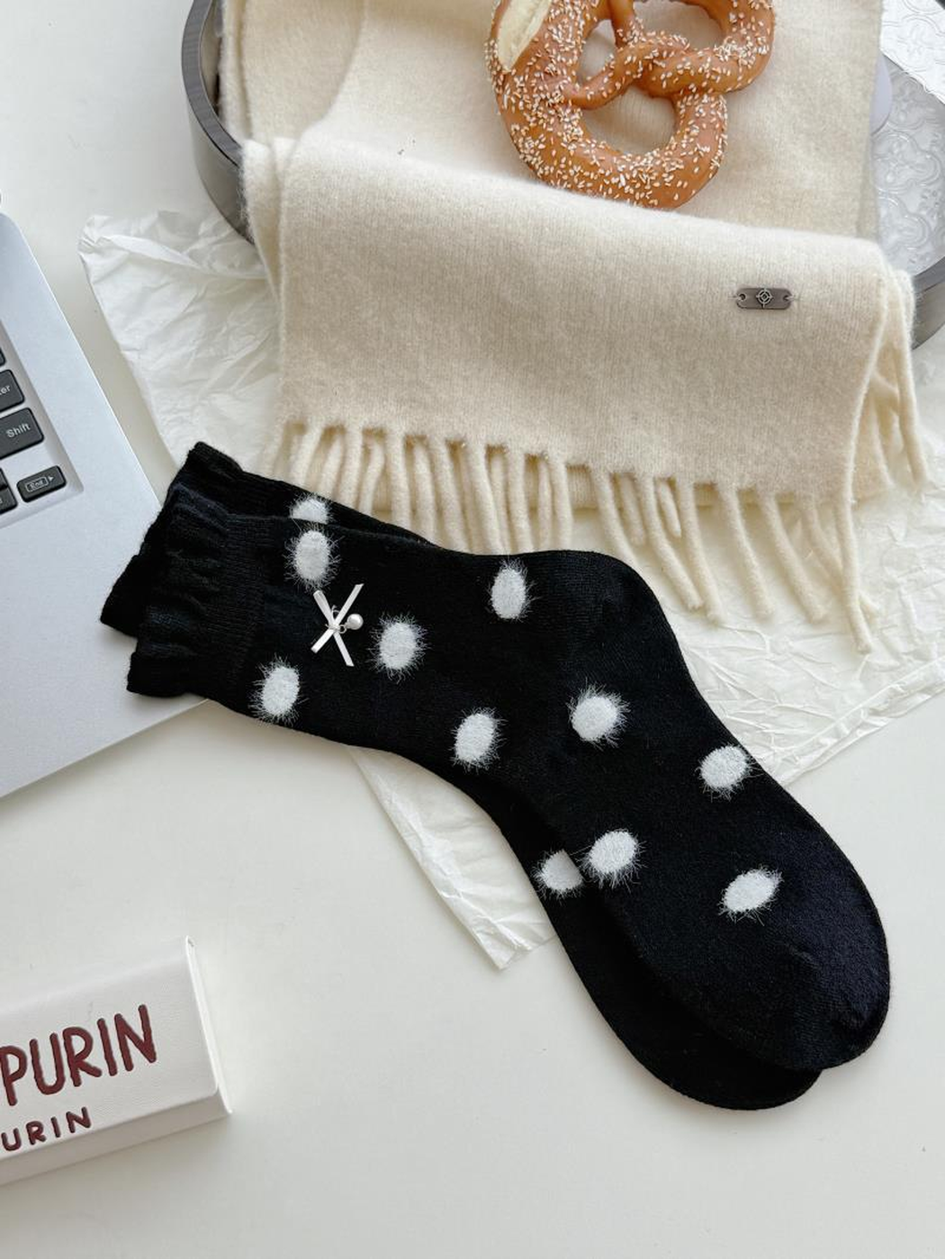 Bow style black socks with fuzzy white polka dots, scalloped cuffs and a small white bow.