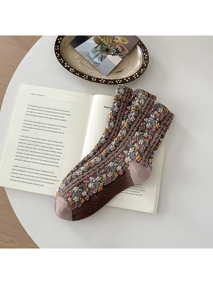 Brown floral socks with pink, yellow and white flowers and taupe toe and heel panels.