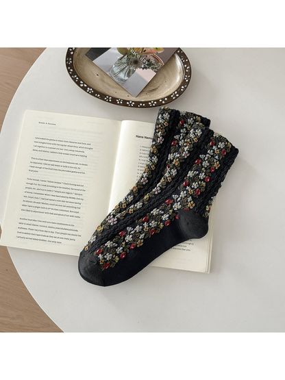 Black floral socks with red and white flowers and textured vertical bands.