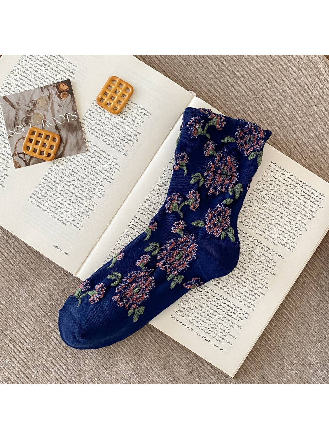Navy sock with raised pink flowers, green leaves and plain toe and heel sections.