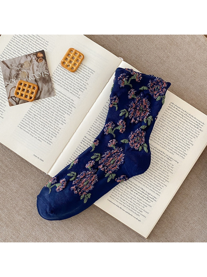 Navy sock with raised pink flowers, green leaves and plain toe and heel sections.