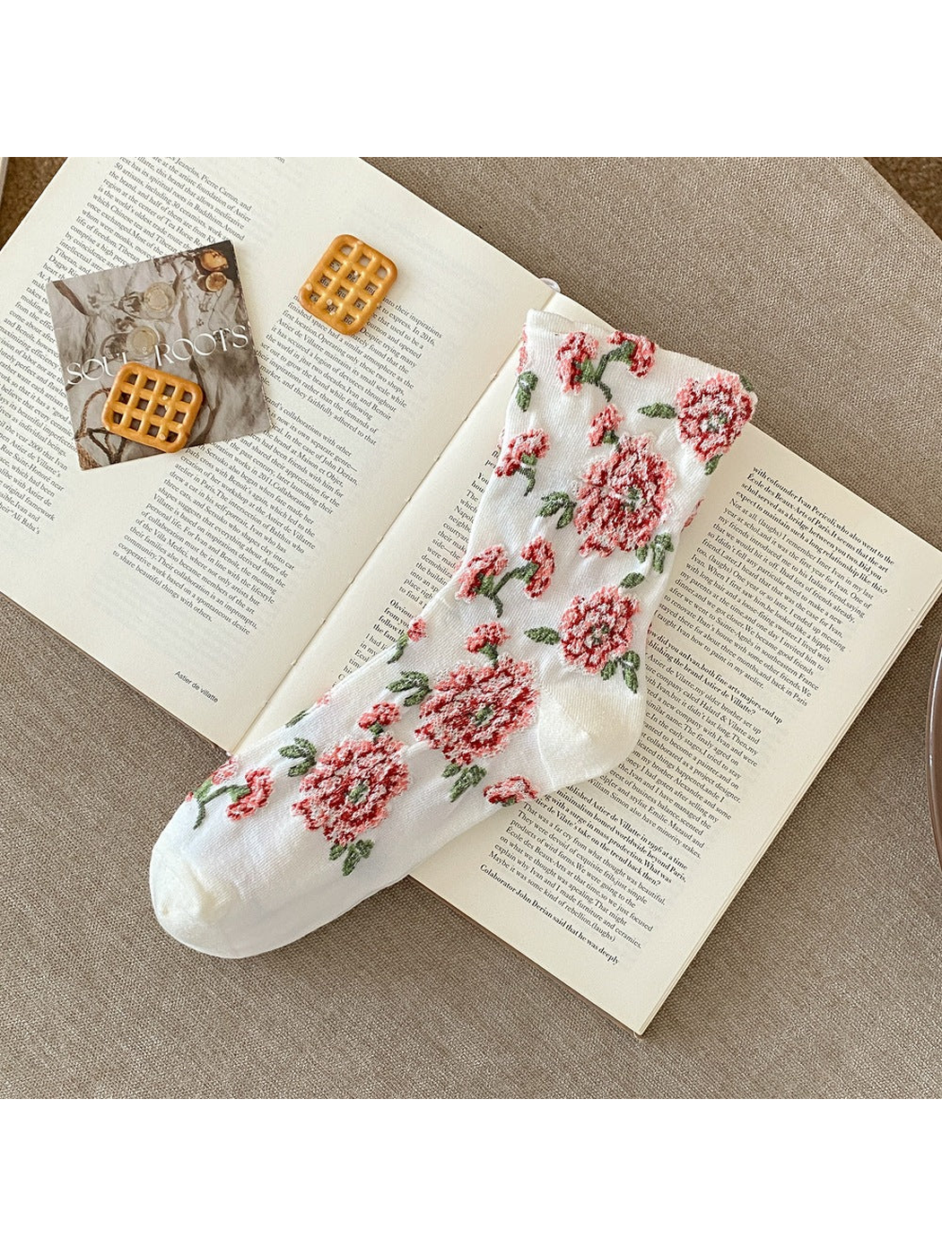 White sock with raised red flowers, green leaves and plain toe and heel sections.