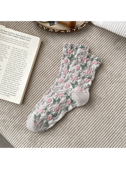 Light Gray socks with pink flowers, green leaves and raised scrolling texture.