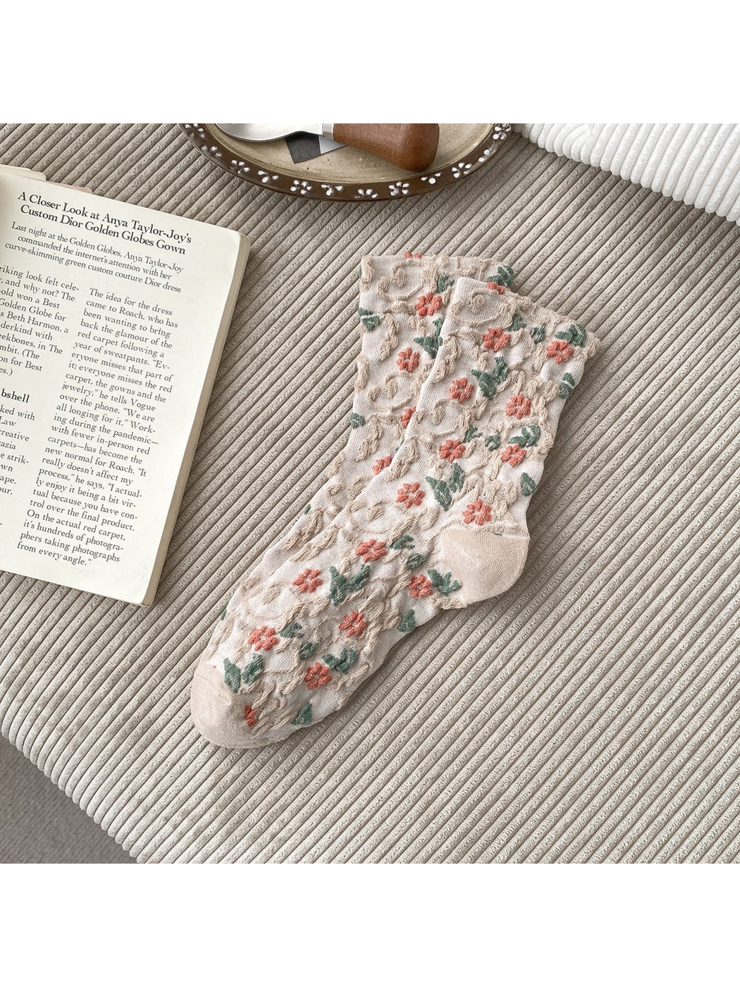 Beige socks with coral flowers, green leaves and raised scrolling texture.