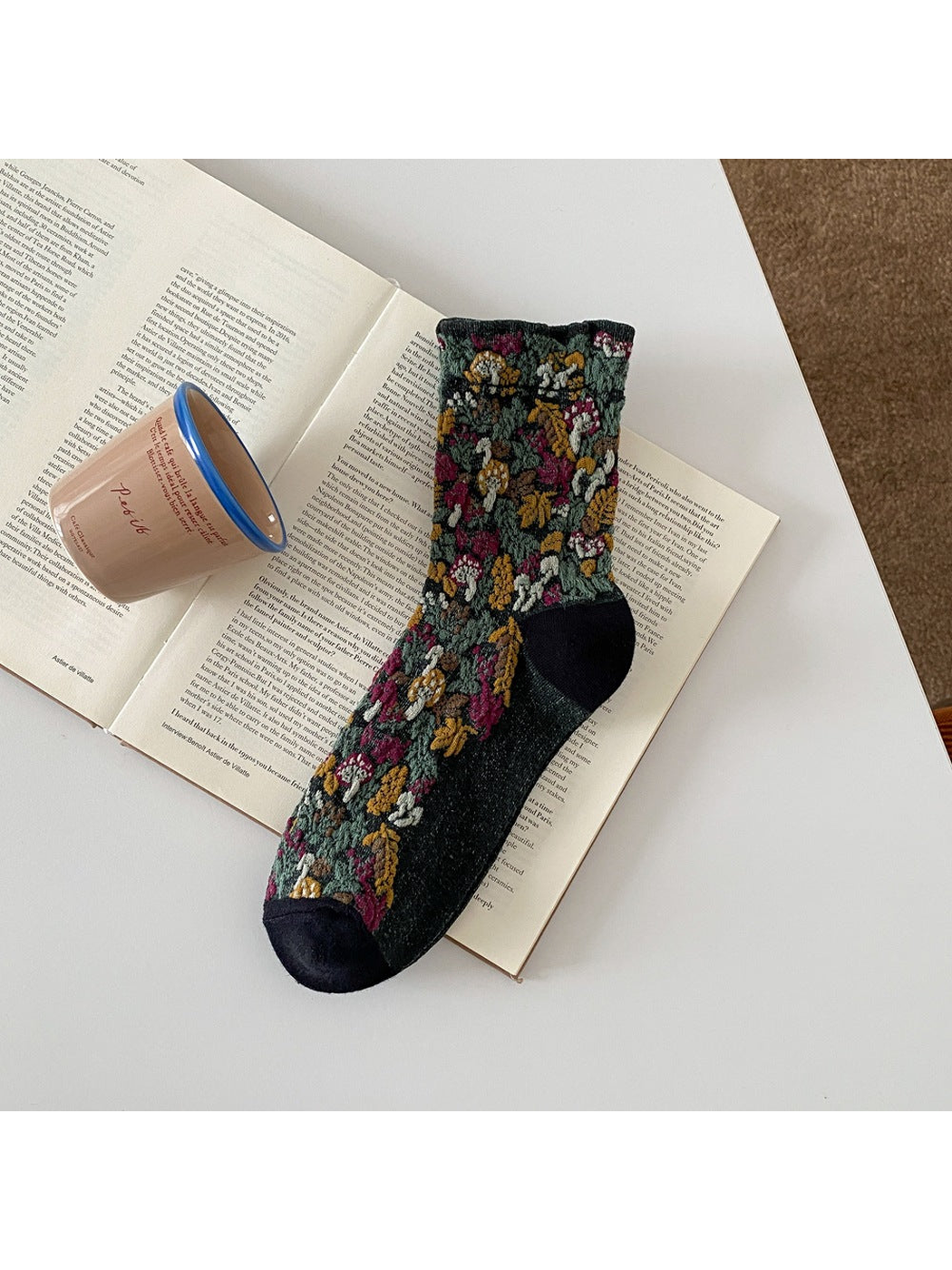 Black sock with raised mushroom and foliage motifs and a ribbed cuff.