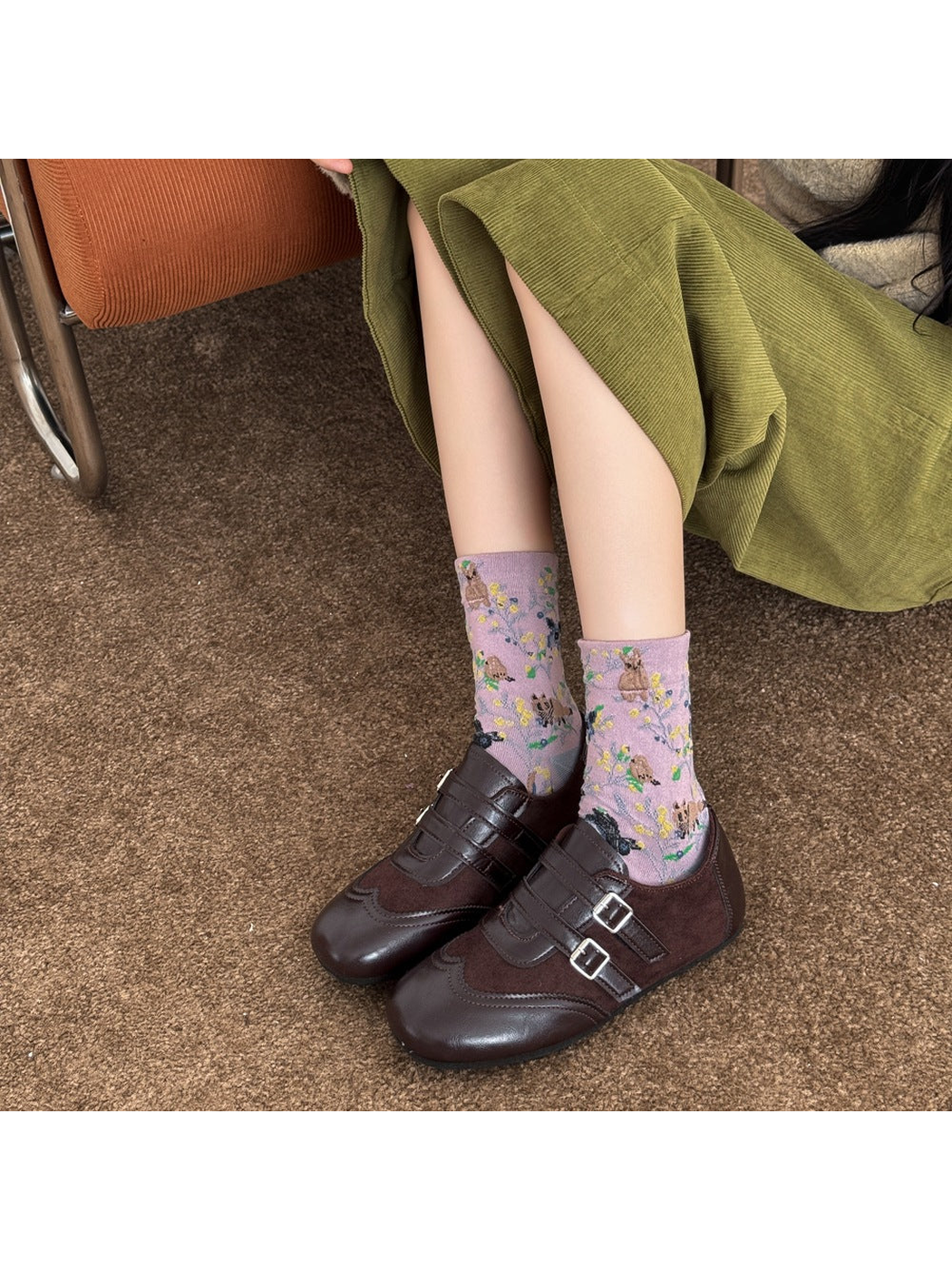 Purple animal and botanical patterned socks worn with brown buckle shoes.