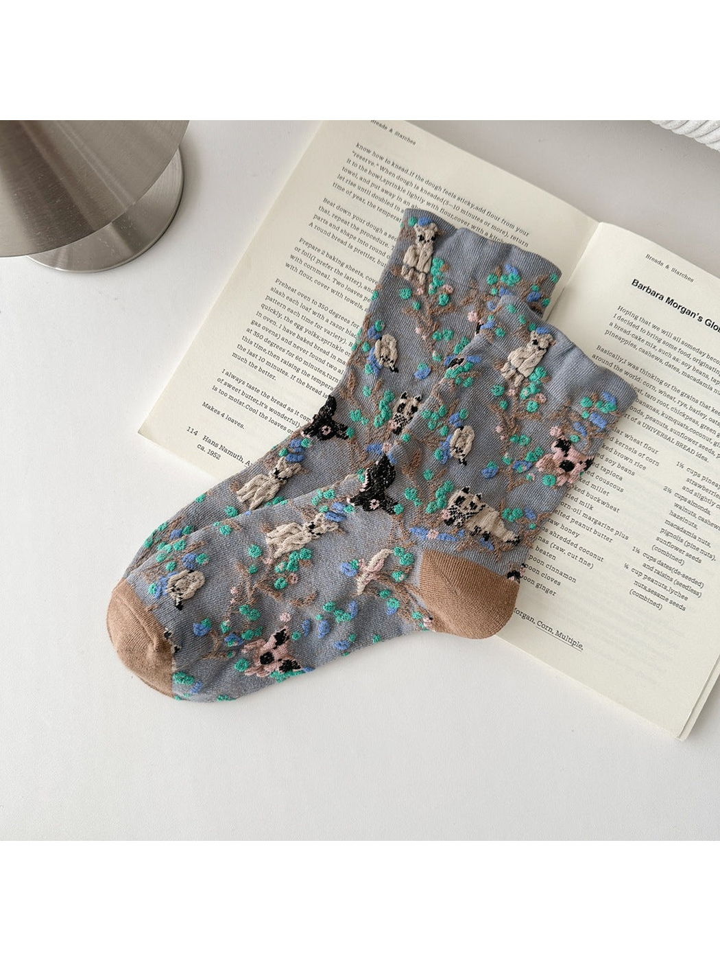 Gray socks with animal and botanical patterns and brown toes and heels.