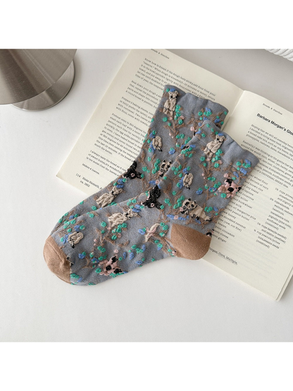 Gray socks with animal and botanical patterns and brown toes and heels.