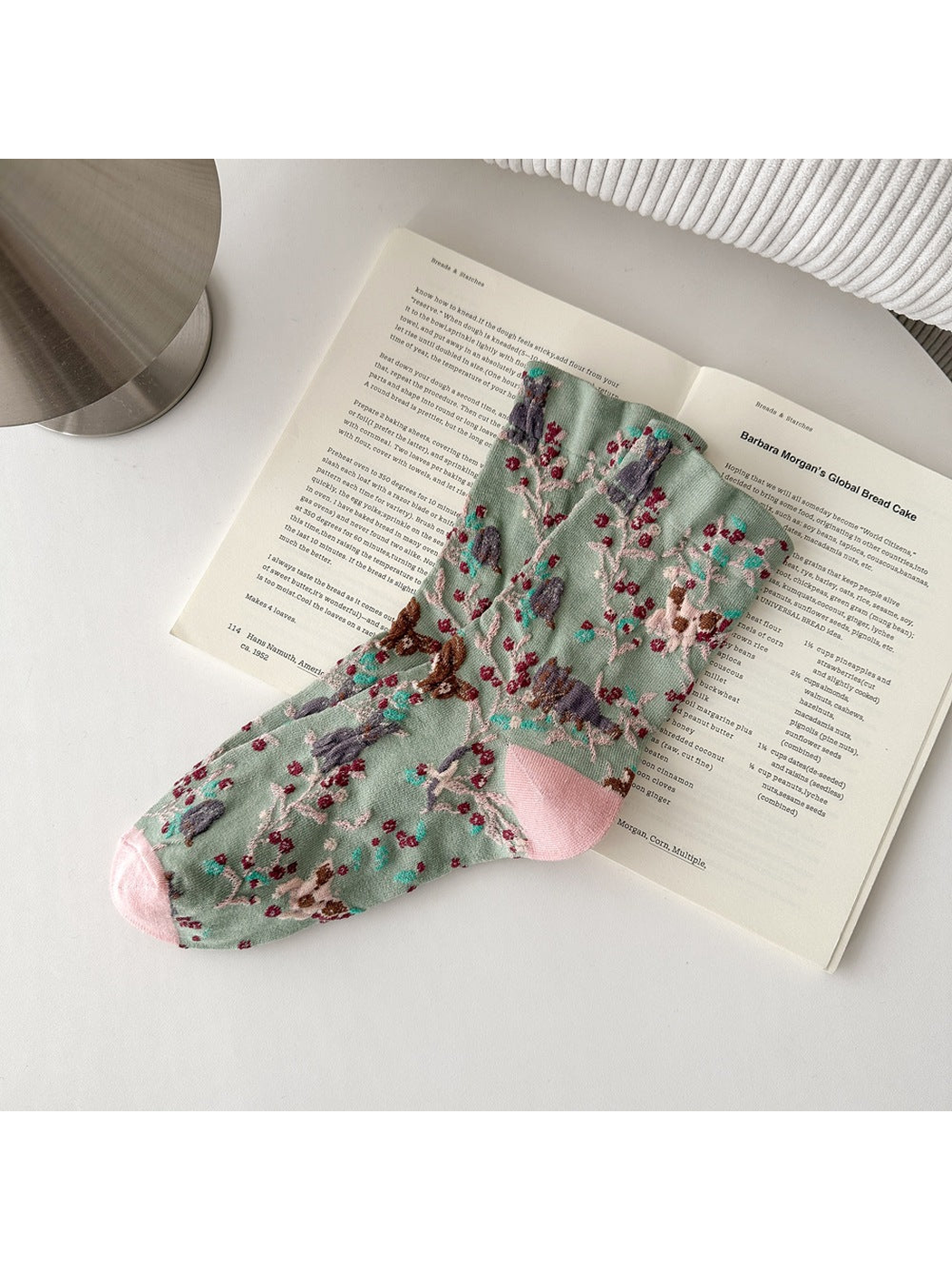 Green socks with animal and botanical patterns and pink toes and heels.