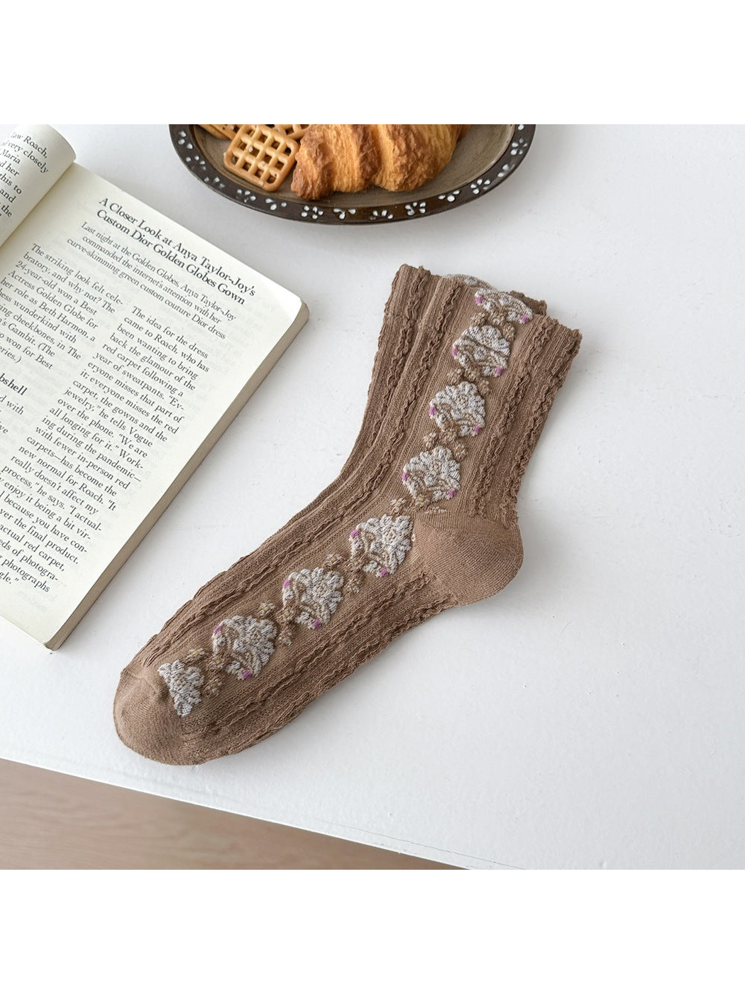 Brown sock laid flat with repeating floral medallions and textured vertical ribbing.