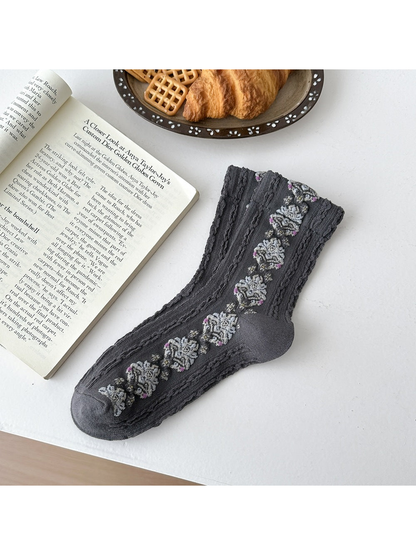 Dark Gray sock laid flat with repeating floral medallions and textured vertical ribbing.