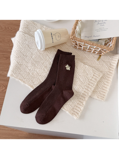 Brown ribbed socks with a yellow checked dog motif and multicolored flecks.