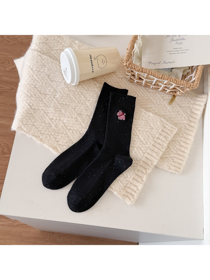Black ribbed socks with a red checked dog motif and multicolored flecks.
