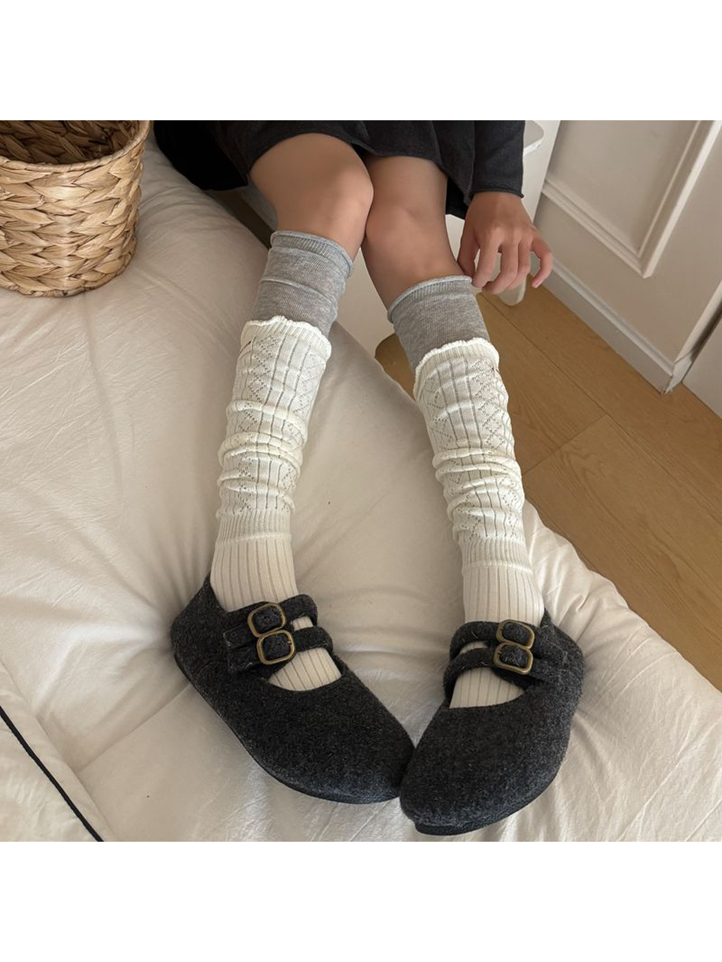 Ivory patterned socks worn with dark double-buckle shoes while seated.
