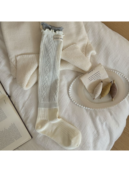 Ivory sock with diamond pointelle, vertical ribbing, a ruffled edge and contrasting gray cuff.