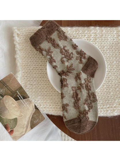 Green sock with raised brown flowers and a contrasting brown cuff, heel and toe.