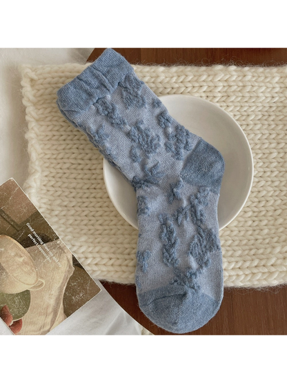 Blue sock with raised darker blue flowers and a folded ribbed cuff.