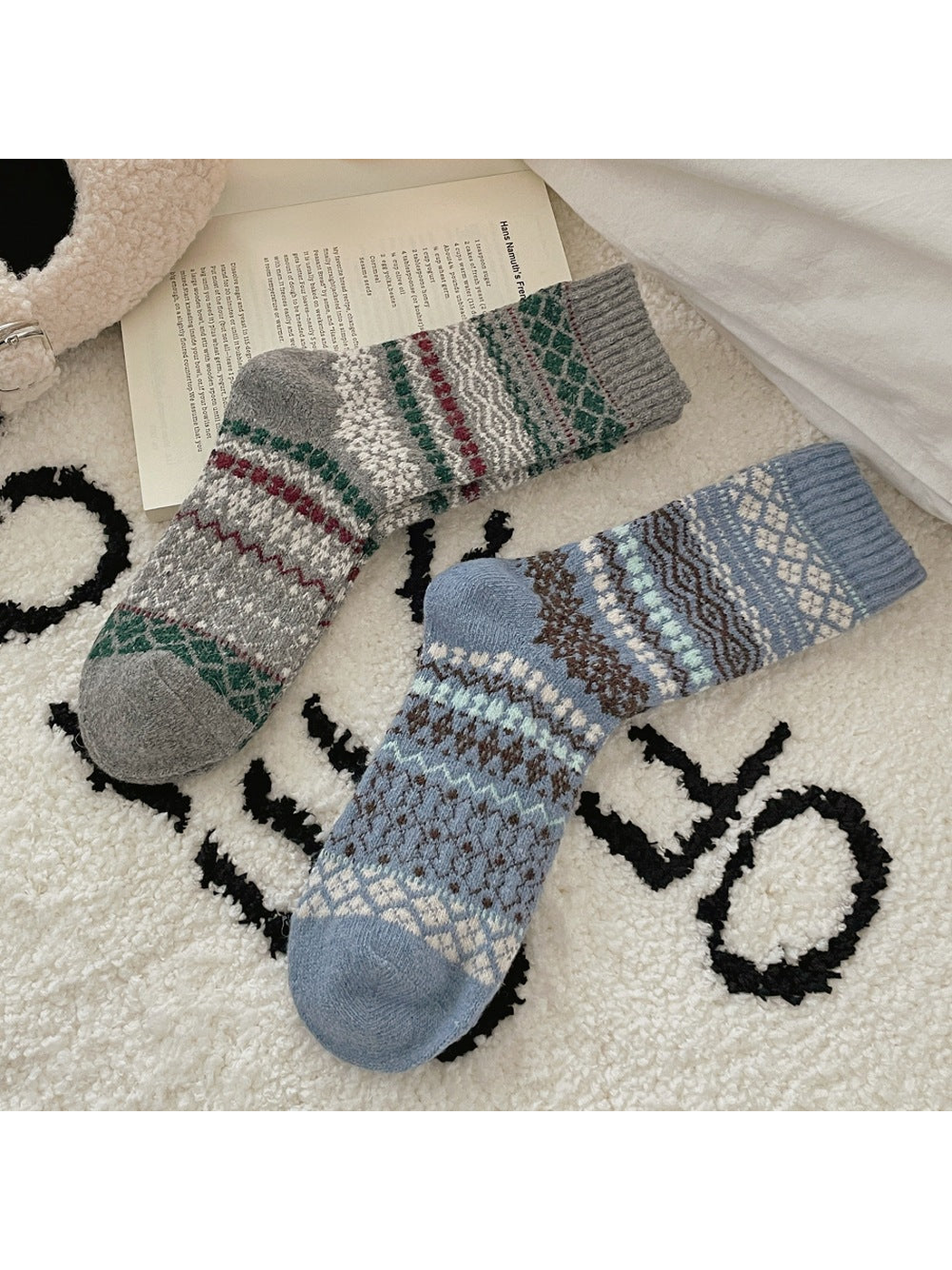 Gray and Blue socks laid side by side, showing geometric bands, ribbed cuffs, shaped heels, and rounded toes.
