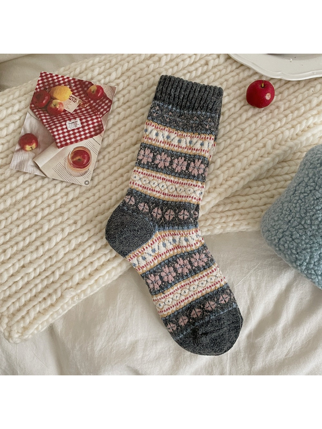 Gray sock with pink floral motifs, cream geometric bands and a dark ribbed cuff, heel and toe.
