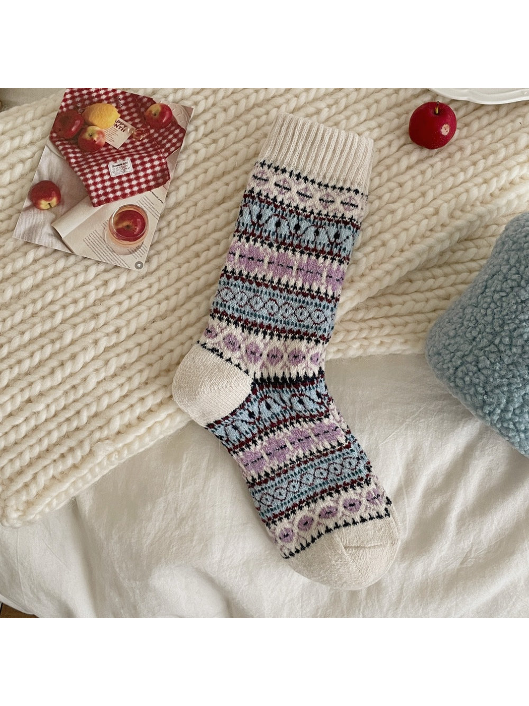 Blue sock with floral and geometric bands and a cream ribbed cuff, heel and toe.