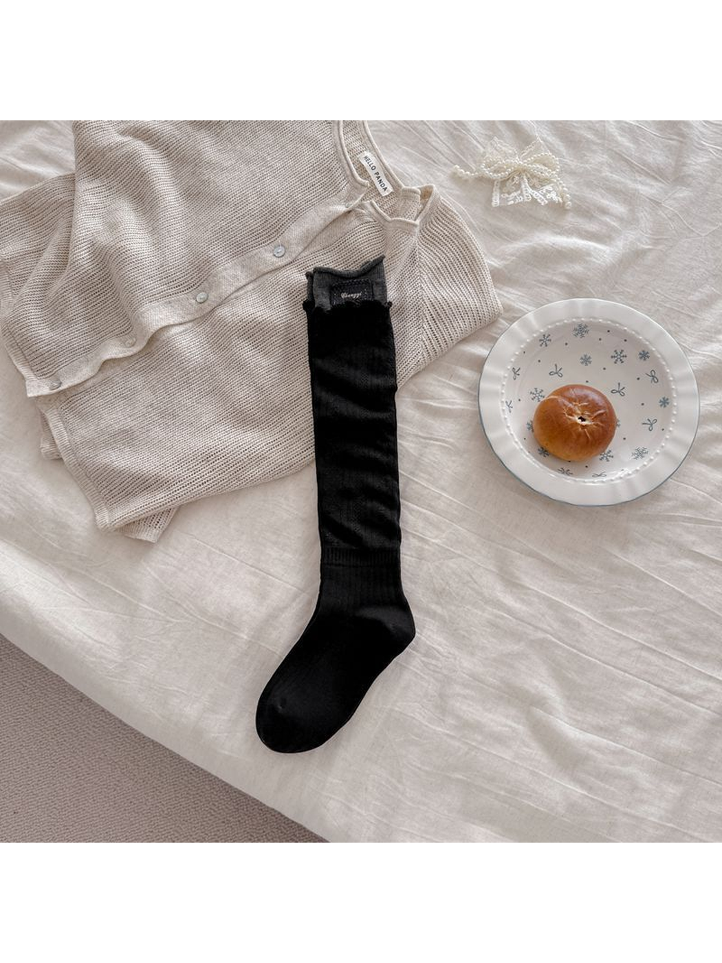 Black sock laid flat with a contrasting gray cuff and rectangular patch.