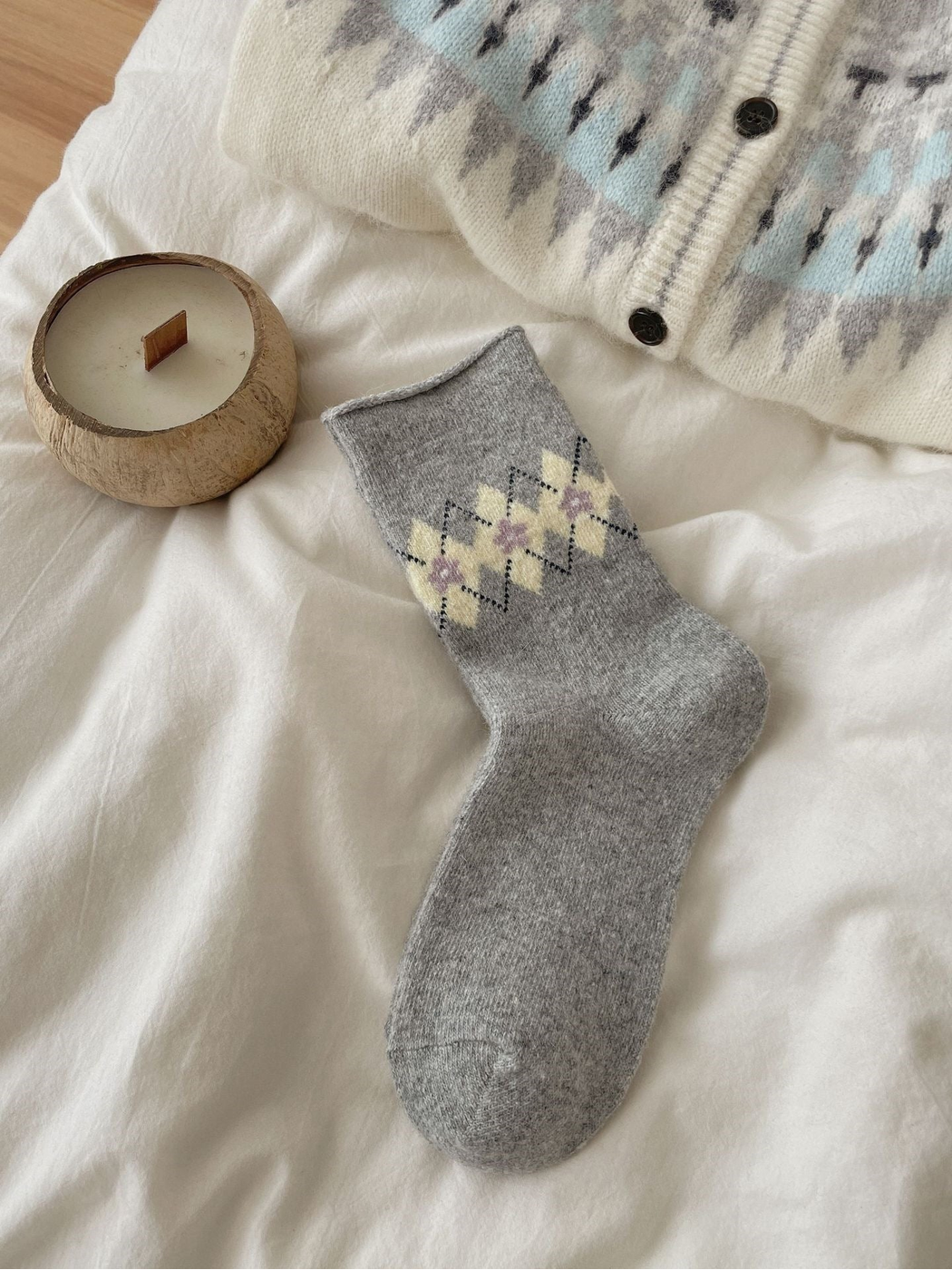 Gray sock with yellow flowers, purple centers, dotted diamonds, and a rolled cuff.