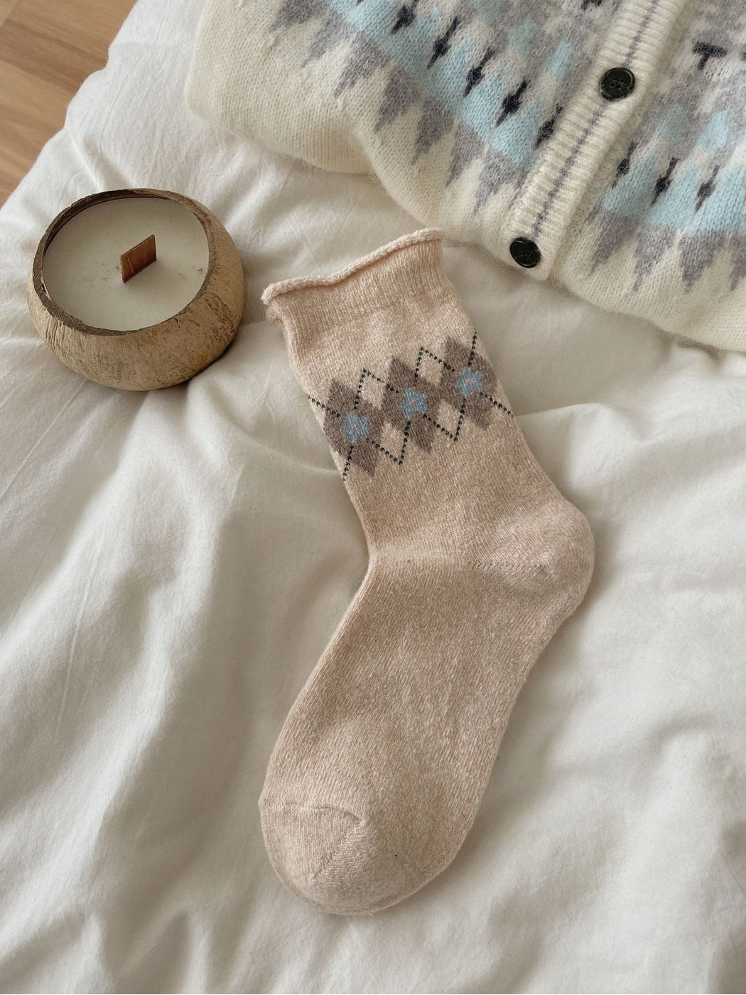 Beige sock with taupe flowers, blue centers, dotted diamonds, and a rolled cuff.