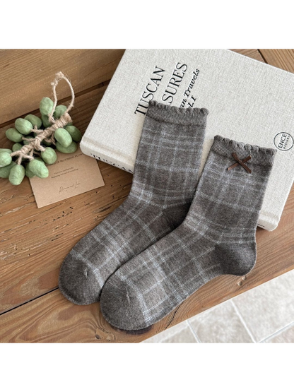 Heather gray Plaid socks with ruffled cuffs and a brown ribbon bow.