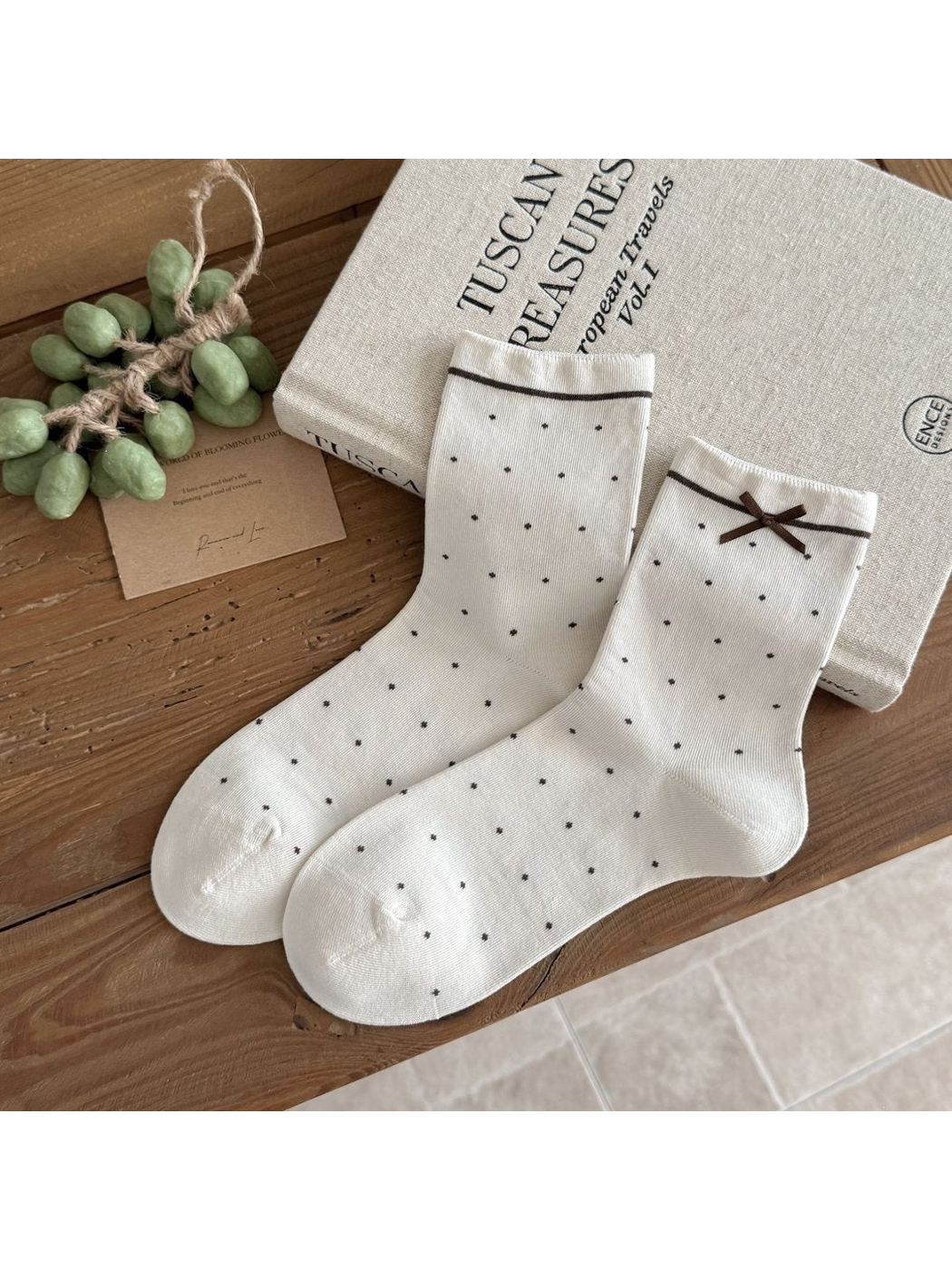 Ivory Small Dots socks with dark dots, a thin stripe below each cuff and a brown ribbon bow.