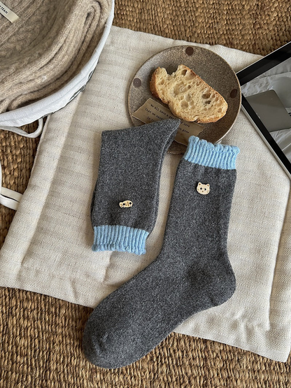 Blue color socks with dark gray bodies, light blue ribbed cuffs, and cat face and fish emblems.