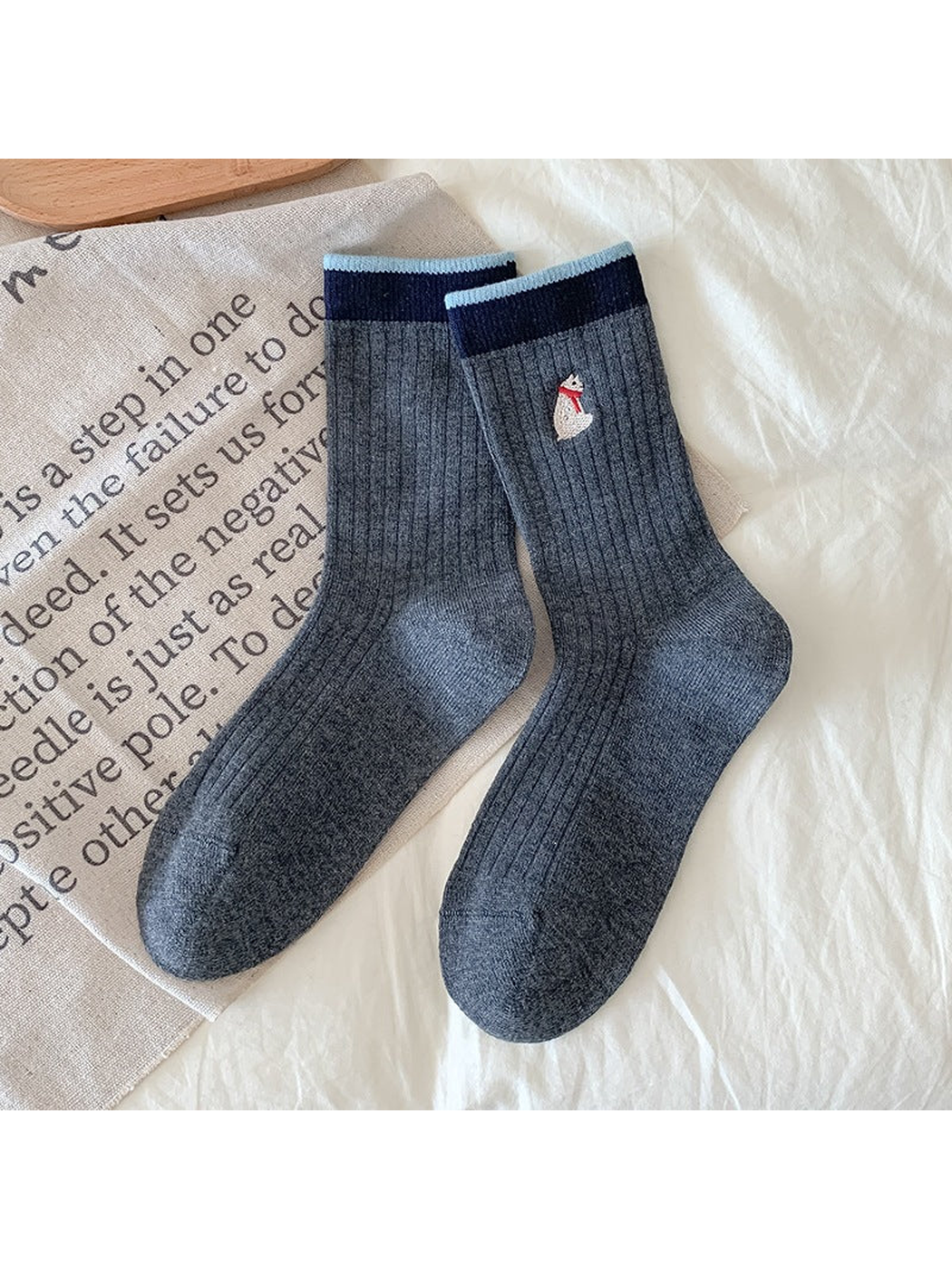 Dark gray Bear socks with ribbing, contrasting cuffs, and a bear embroidered with a red scarf.