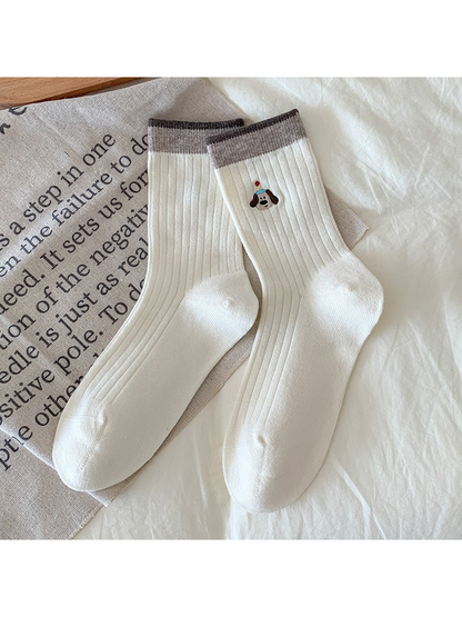 Ivory Dog socks with ribbing, contrasting cuffs, and an embroidered dog wearing a hat.