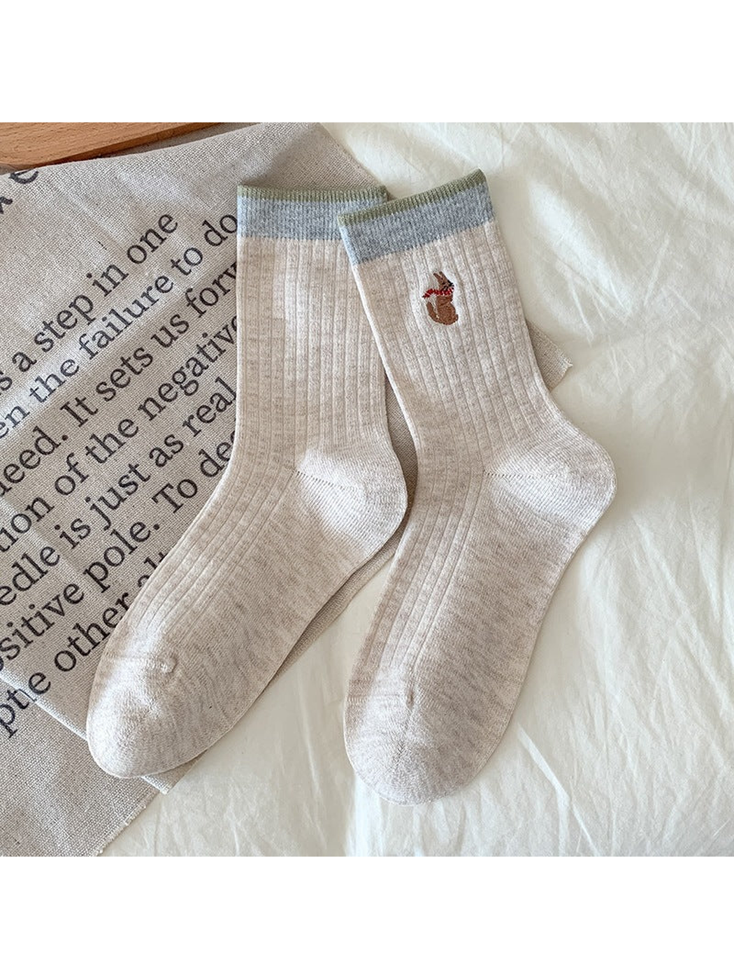 Beige Kangaroo socks with ribbing, contrasting cuffs, and an embroidered kangaroo with a red scarf.