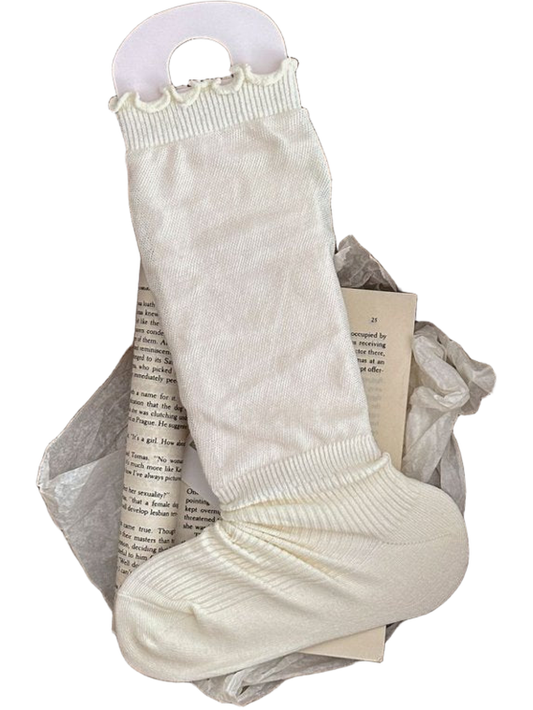 Ivory sock with a ruffled cuff and ribbed ankle and foot displayed in a woven basket.