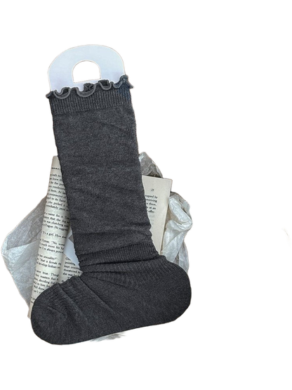 Dark Gray sock with a ruffled cuff and ribbed ankle and foot displayed in a woven basket.