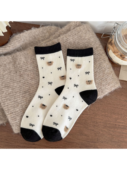 Ivory socks with black cuffs, heels and toes, fuzzy bear heads, bows, dots and hearts.