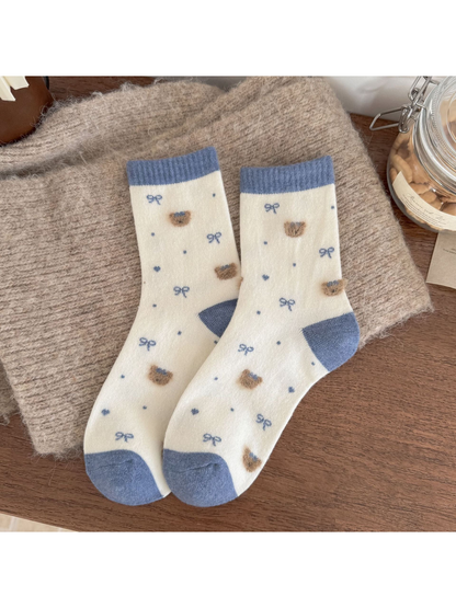 Ivory socks with blue cuffs, heels and toes, fuzzy bear heads, bows, dots and hearts.