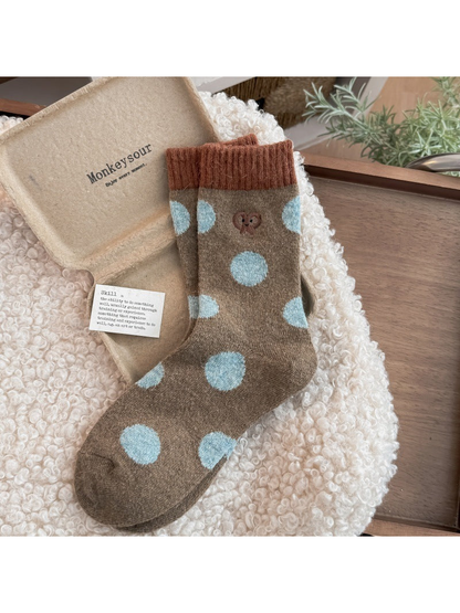 Pretzel socks with light blue polka dots, a pretzel motif, and contrasting ribbed cuffs.