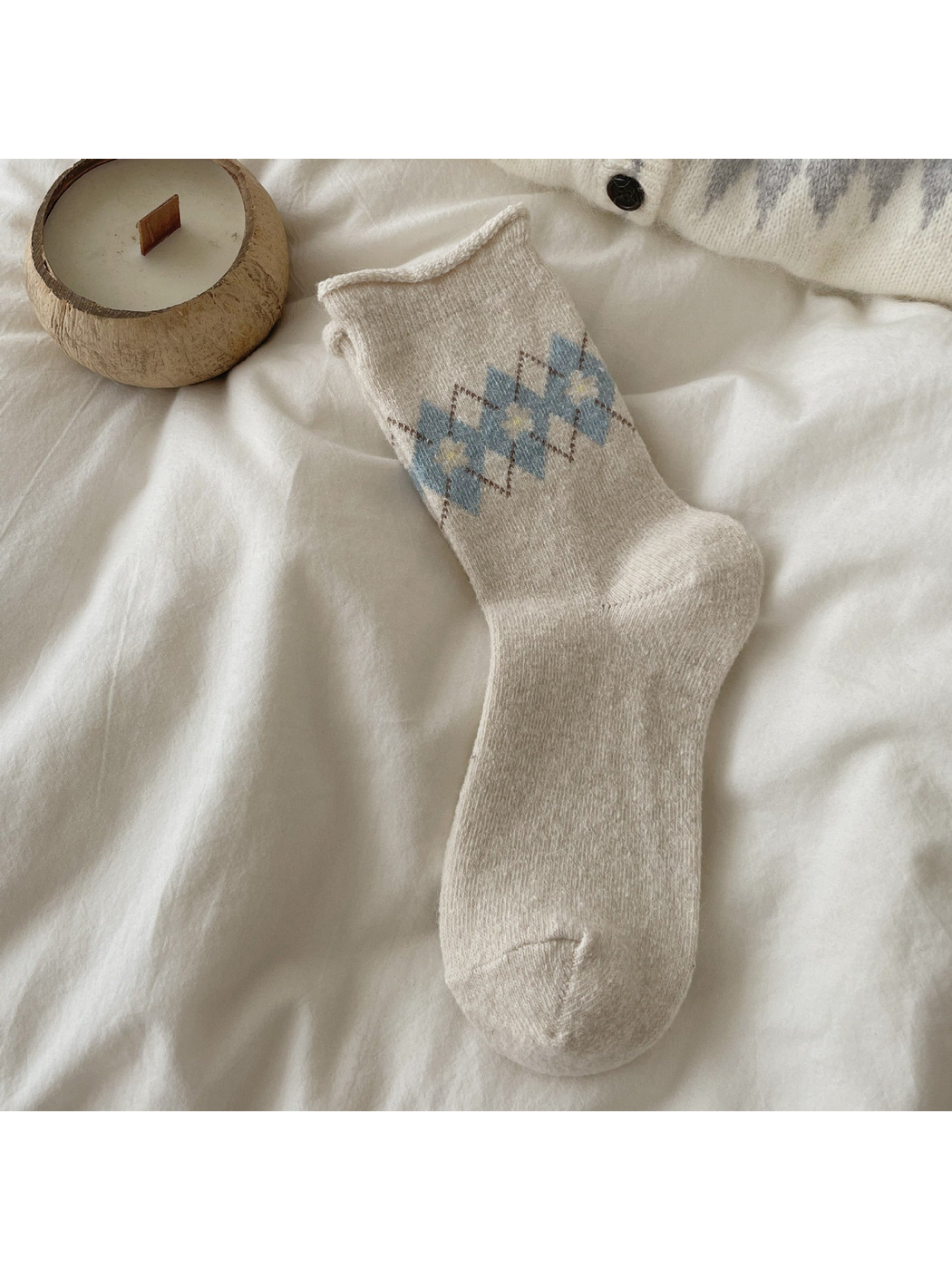 Ivory sock with blue argyle diamonds, pale yellow floral centers, and a rolled cuff.