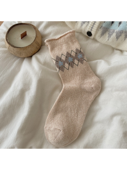 Beige sock with brown argyle diamonds, light blue floral centers, and a rolled cuff.