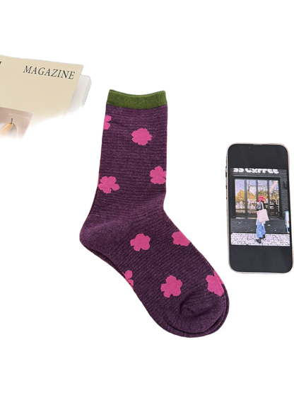Purple sock with bright pink flowers and a green cuff.