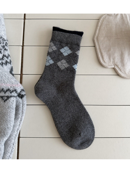 Dark Gray sock with pale blue and gray argyle diamonds, a ribbed cuff and a black top edge.