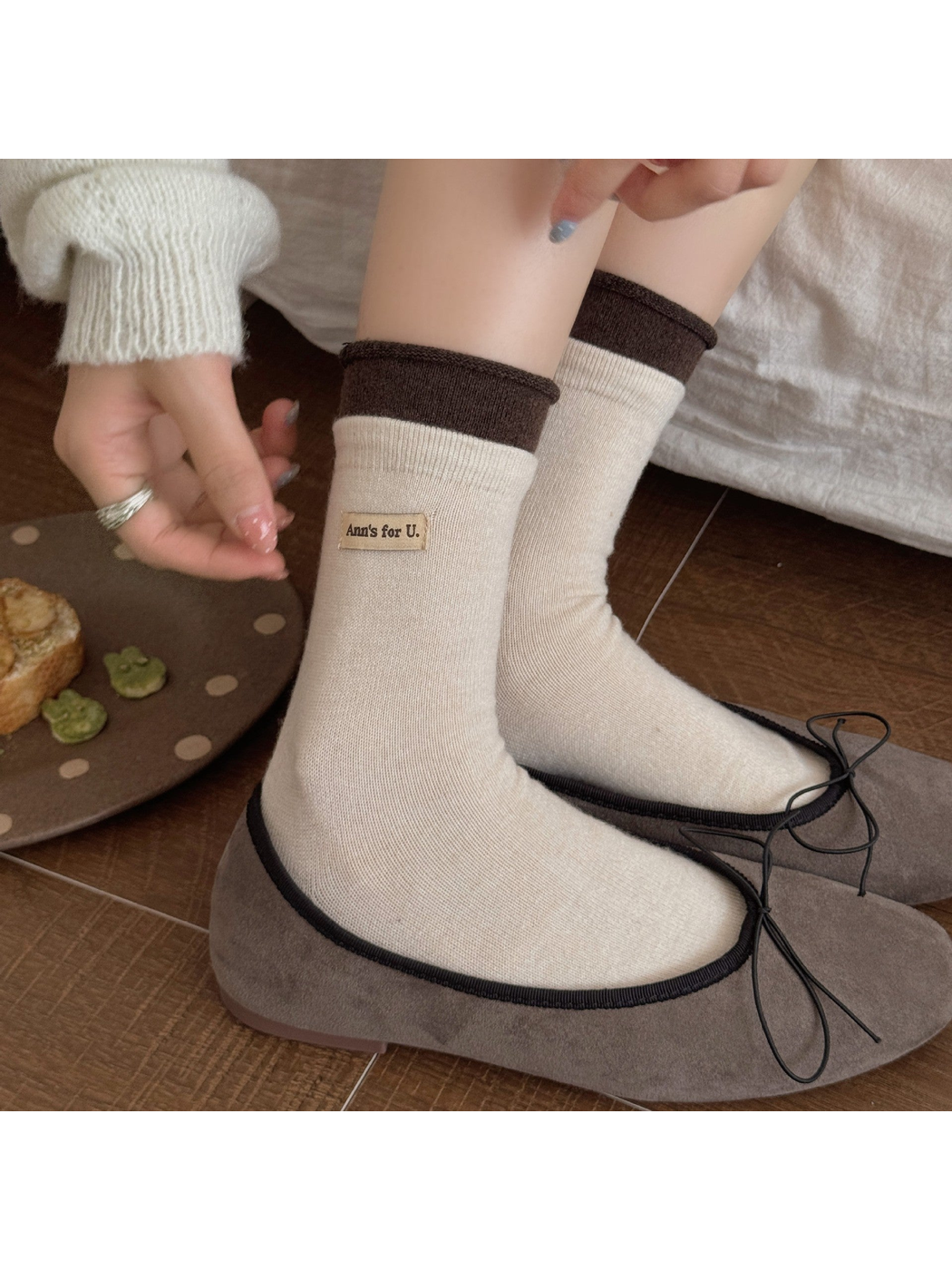 Ivory socks with dark brown rolled cuffs worn with bow-trim flats.